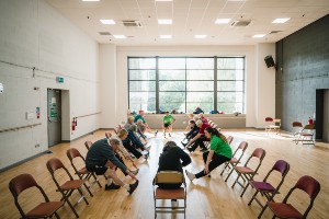 group of people in centre stretching whilst sitting down