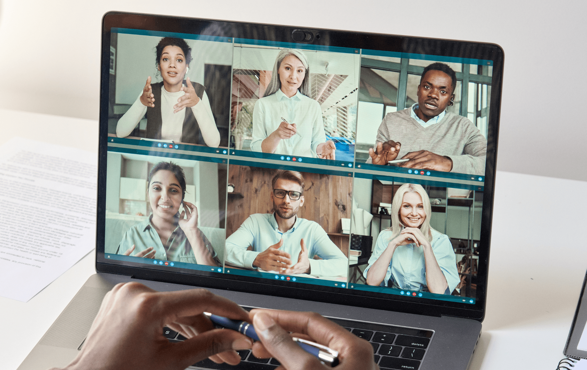 Seven colleagues in a remote work meeting on their laptops.