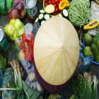 WOMAN SELLING VEGETABLES AT A MARKET IN HANOI