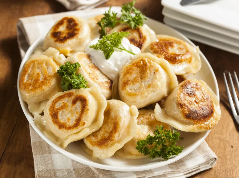 A Plate of Pierogis With Sour Cream 
