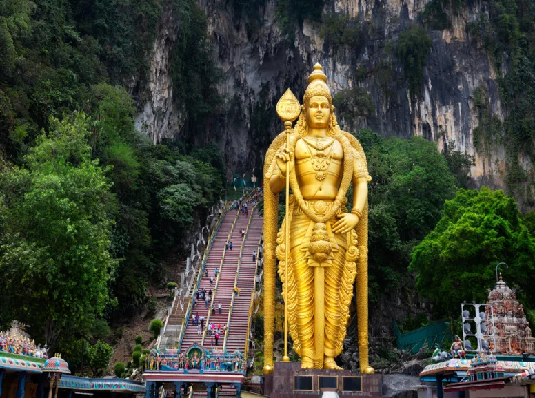 Entrance to the Batu Caves with golden statue and grand staircase