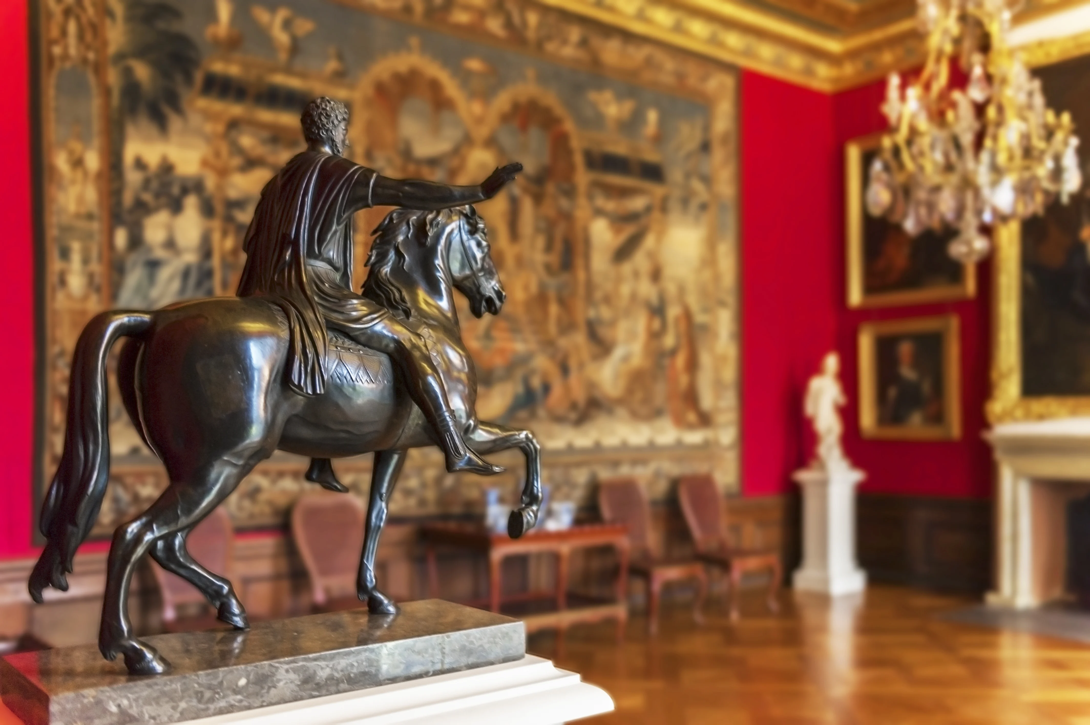 A Small Bronze Statue of a Horseman in Front of a Tapestry