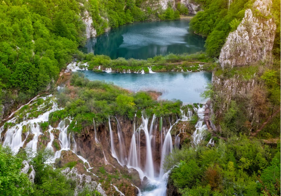 A Waterfall Spilling from a Lake Down a Rocky Cliff Face 