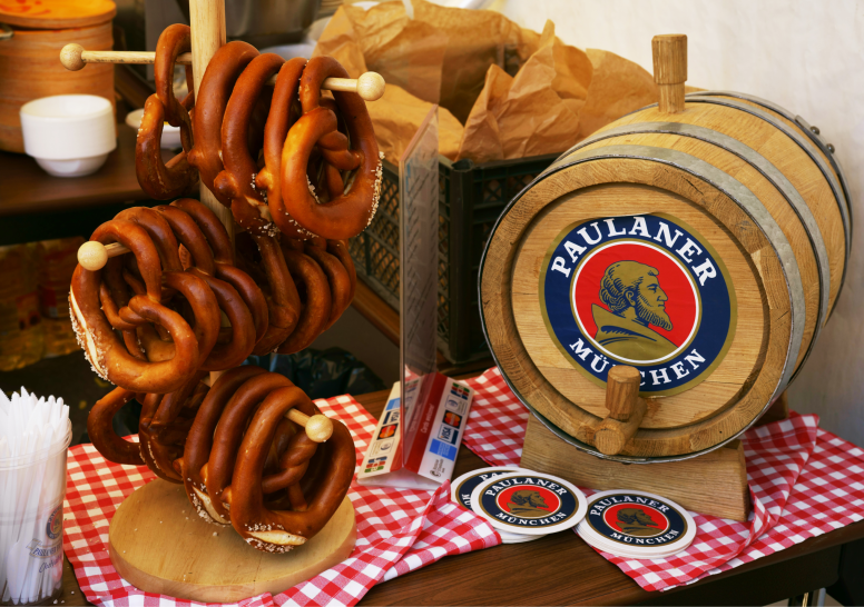Rows of Pretzels Next to a Beer Barrel on a Red Checked Table Cloth