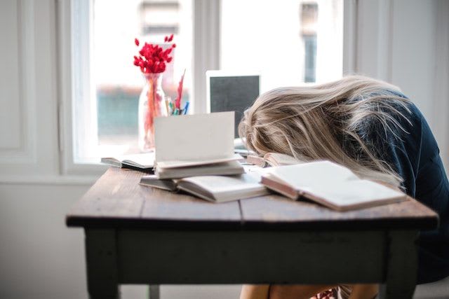 The homework load is taking its toll. This student looks exhausted and stressed.