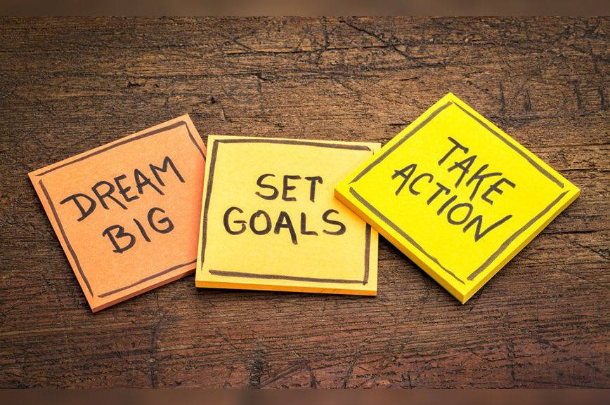 3 sticky pads, the first saying Dream Big, the second saying Set Goals, and the third saying Take Action.