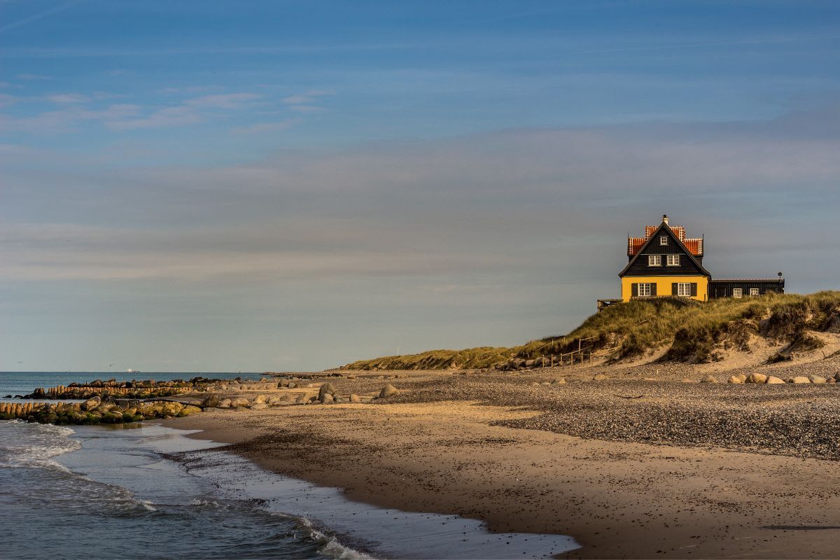 Alleinstehendes Haus auf einer Düne am ruhigen Strand von Skagen in Dänemark, ein romantischer Ort für Hochzeiten.