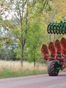 Packers - Kverneland Packomat compact and transported above ground level, dragged by tractor in a folded shape