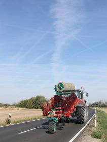 Packers - Kverneland Packomat compact and transported above ground level, dragged by tractor in a folded shape