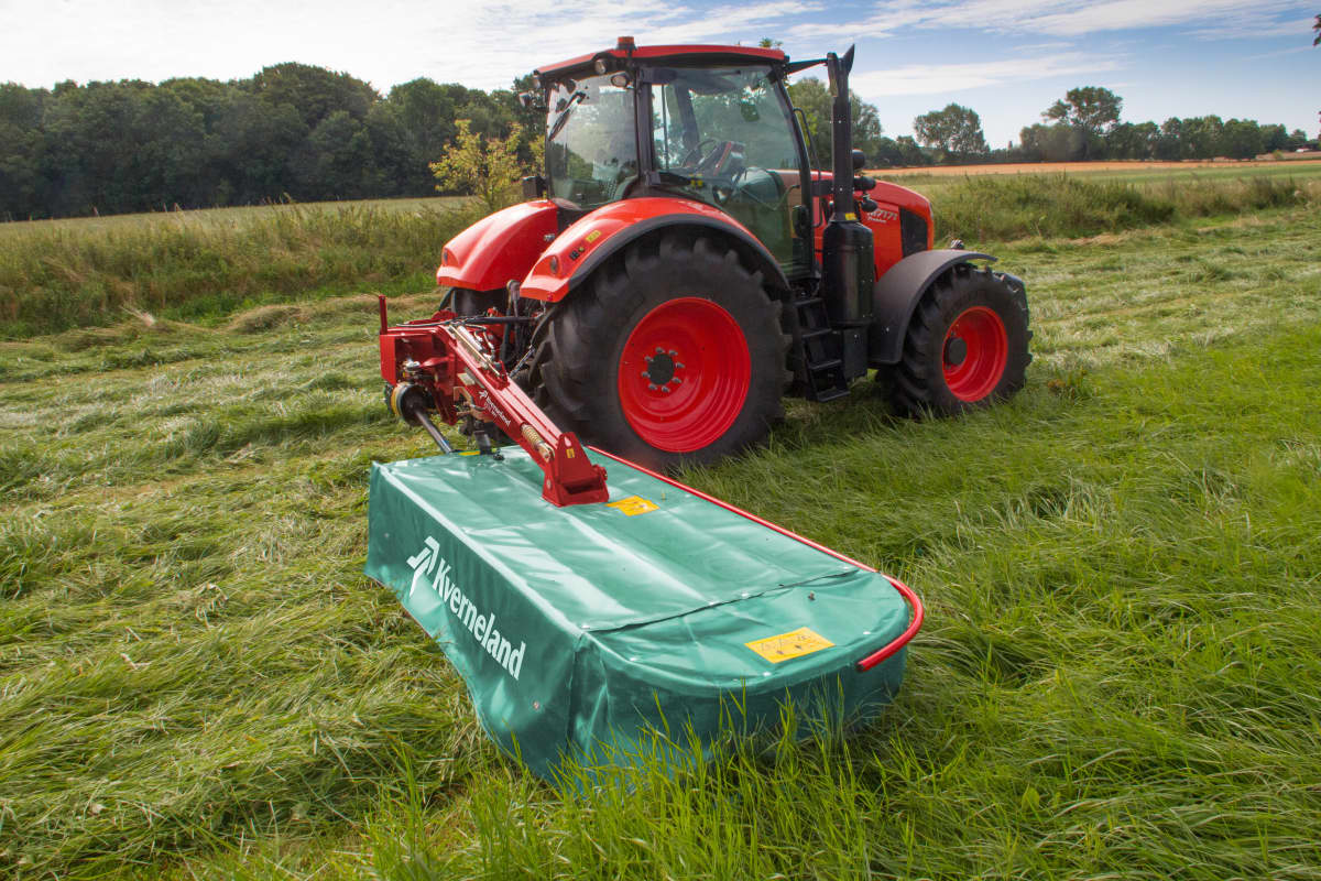 Plain Mowers - Kverneland 2500 M on field mowing the field with tractor