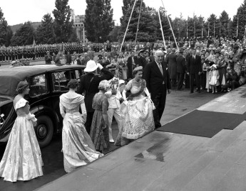 Escorted up the front steps by Prime Minister Robert Menzies, the Queen arrives to open parliament on 15 February 1954.