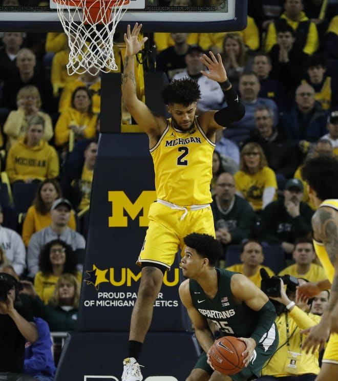 Michigan Wolverines forward Isaiah Livers jumps in the air defending Michigan State forward Malik Hall