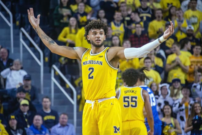 Michigan Wolverines basketball forward Isaiah Livers raises his arms.