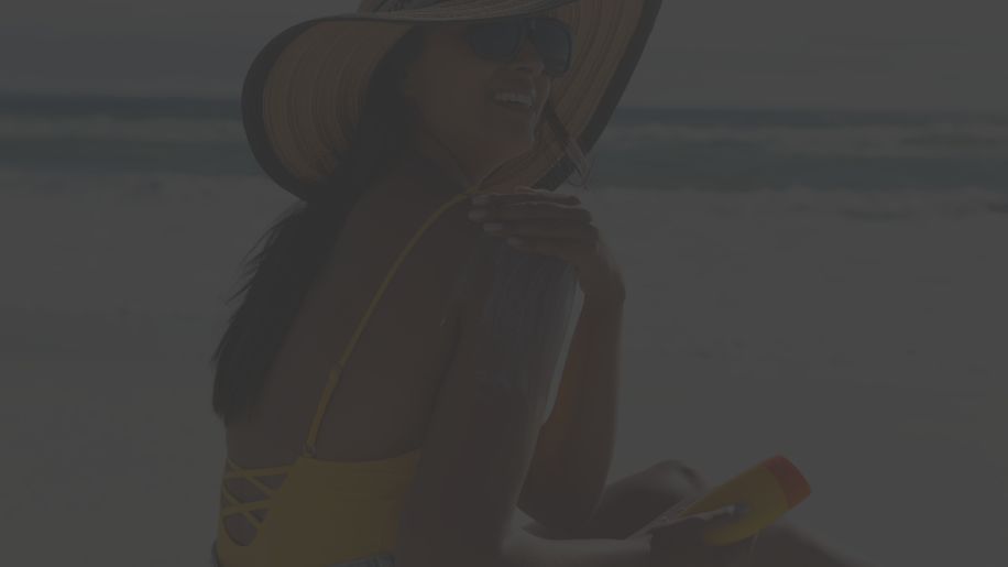 woman applying sunscreen on beach