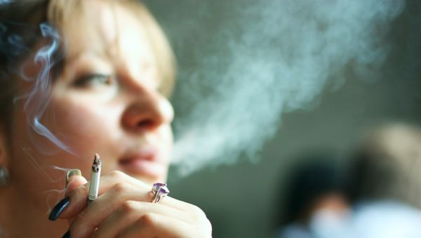 young woman smoking cigarette. Focus on hand