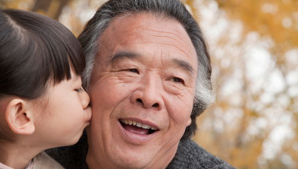 granddaughter kissing grandfather