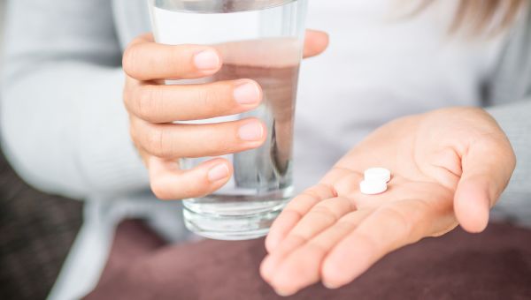 glass of water, pills, hands, medicine, two tablets