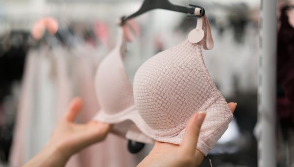 Woman shopping for bras, woman holding bra at retail store