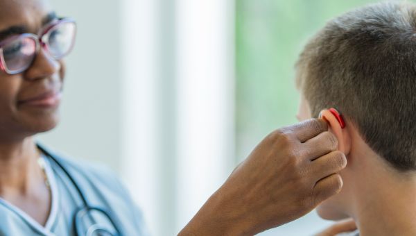 nurse adjusting patient's hearing aid