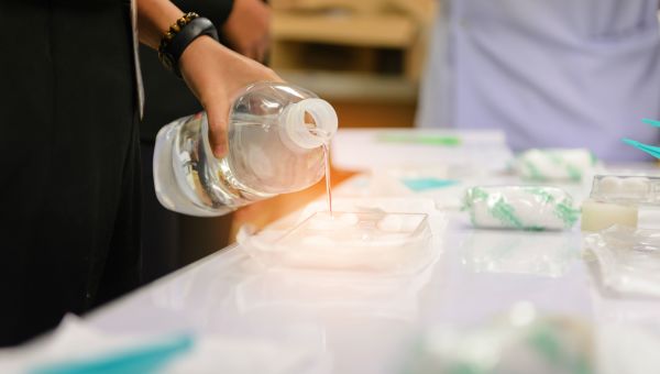 Pouring saline solution into medical kit