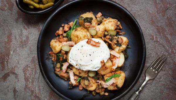 Potato and spinach hash with cornichons, bacon and poached egg