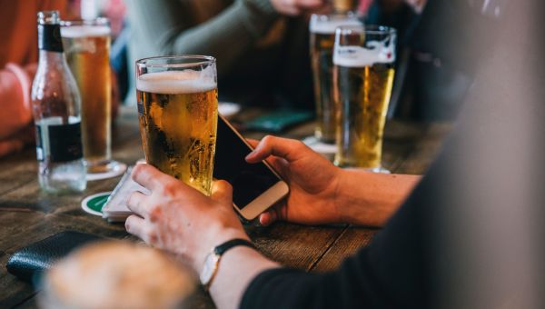 Man holding beer and phone