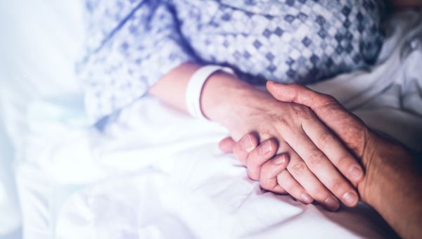 Senior patient holding hands with a loved one
