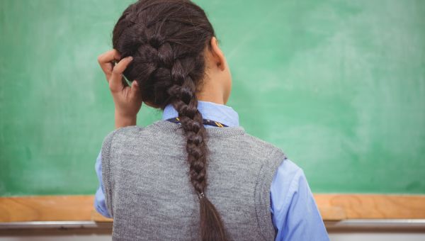 girl scratching itchy head