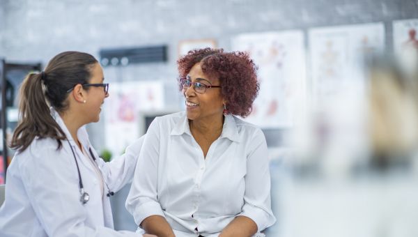 older black person talking to younger HCP
