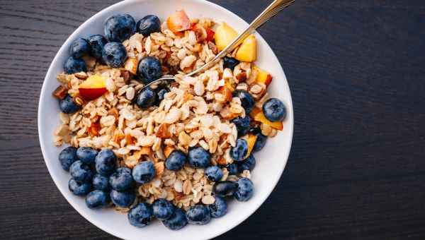 A healthy bowl of oats, blueberries, and peaches.