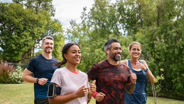 four friends jogging together in a park