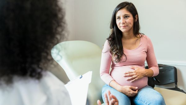A pregnant woman having a conversation with her doctor about bipolar triggers