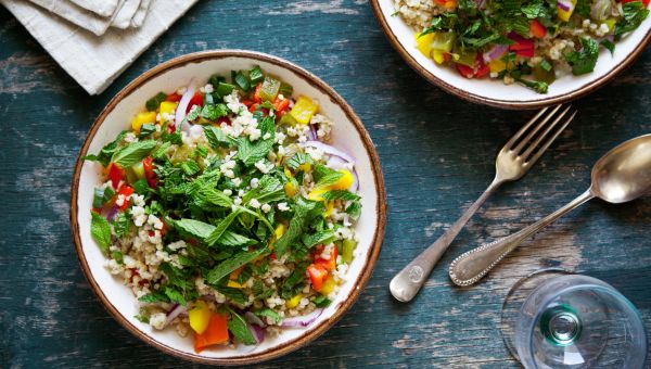a bowl of tabbouleh salad, featuring bulgur wheat, cucumber, tomato, and mint