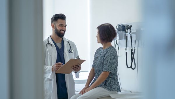 male doctor speaking with mature woman patient