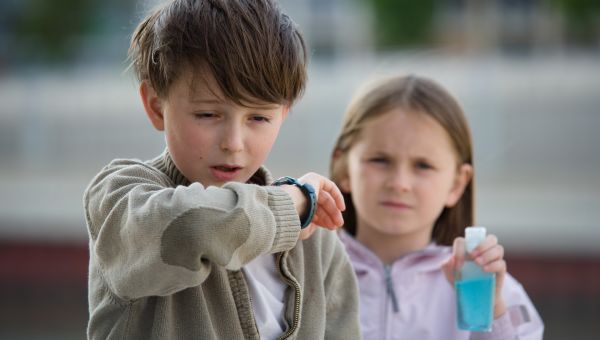 Kid sneezing into arm, cold, flu