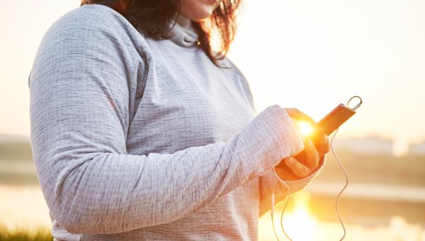 Woman going for a run with music at sunrise.