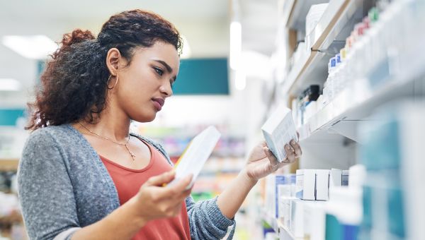 woman at drugstore choosing medication