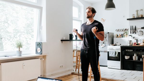 Young man using resistance armbands during a home workout.