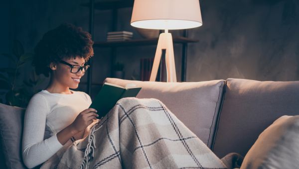 woman reading on couch at night