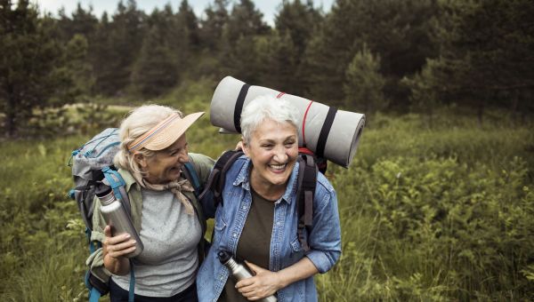 a pair of mature white women couple happily enjoys spending time together on a hike through the mountains
