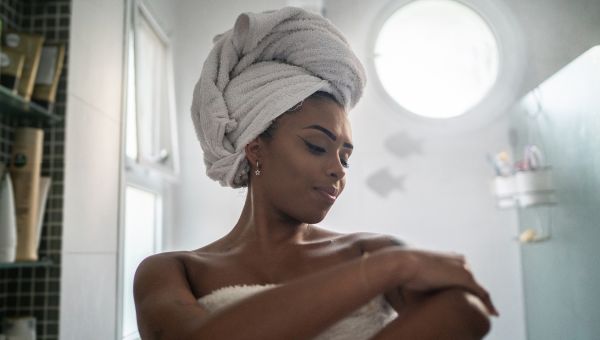 woman applying moisturizer after shower