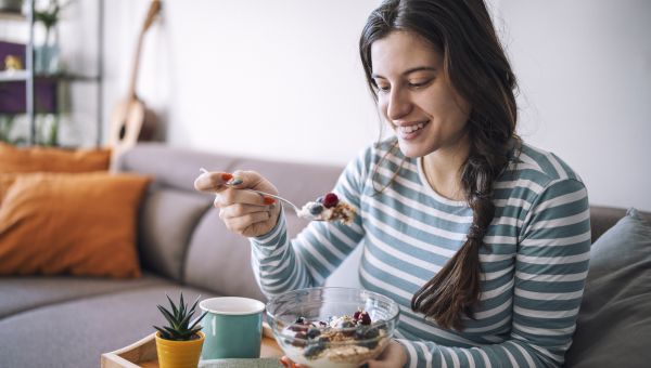 woman eating healthy breakfast with blueberries