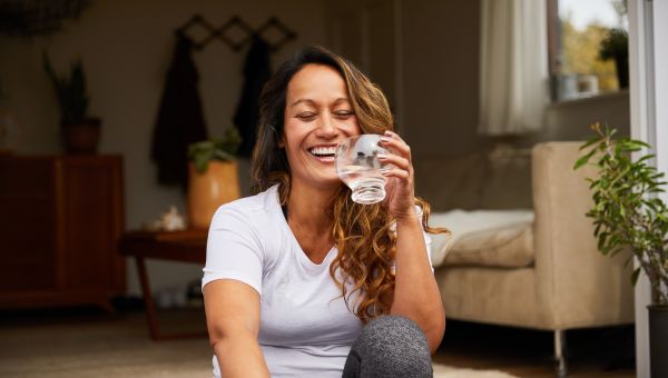 happy woman sitting down and drinking water