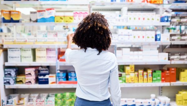 woman selecting skincare product at drugstore