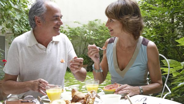 Couple eating breakfast outside.