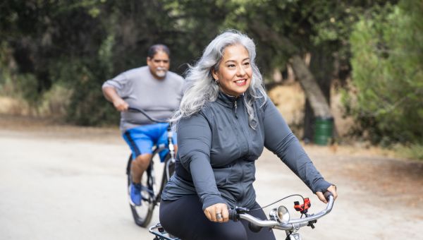 Middle aged person smiling and riding a bike