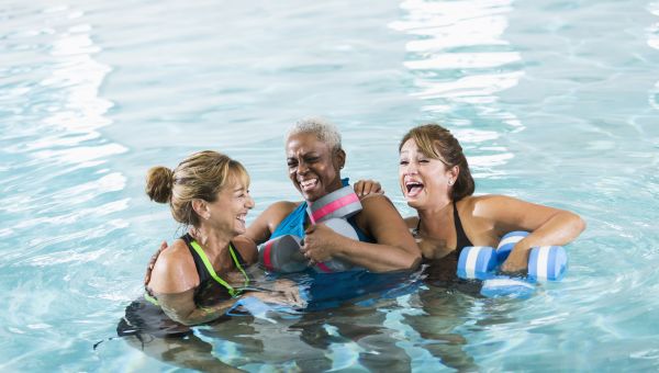 three people having fun together in a pool