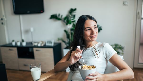 woman happily eating healthy breakfast