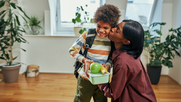 mom kissing her son with autism, celebrating that he has chosen a new food for lunch