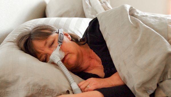 middle aged woman with sleep apnea wearing cpap